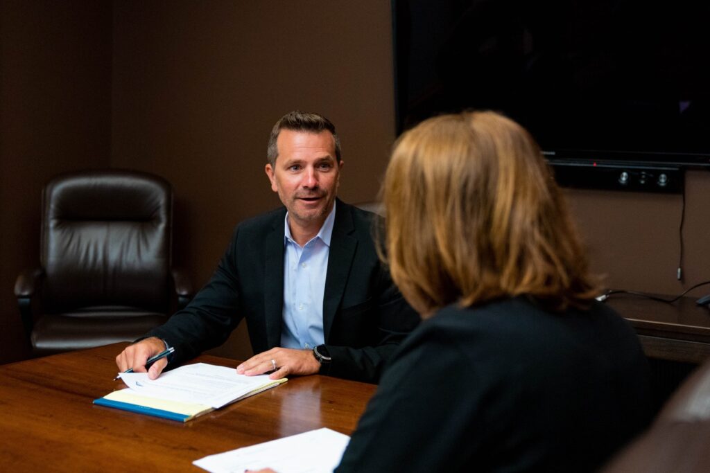 A Kalamazoo financial advisor provides information to a client at a table.