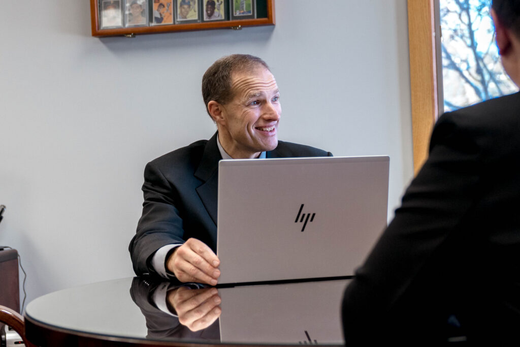 A financial advisor at Wiser Financial Advisors sits with an HP laptop and talks with clients about their finances.